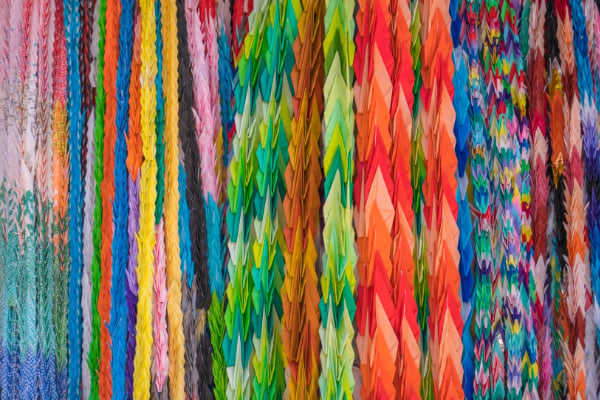 Strings of folded origami cranes - so pretty and colourful!