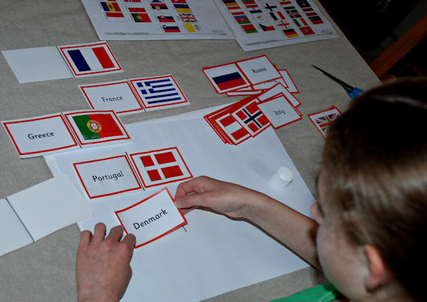 Creating her own flag dominoes using the flag matching cards