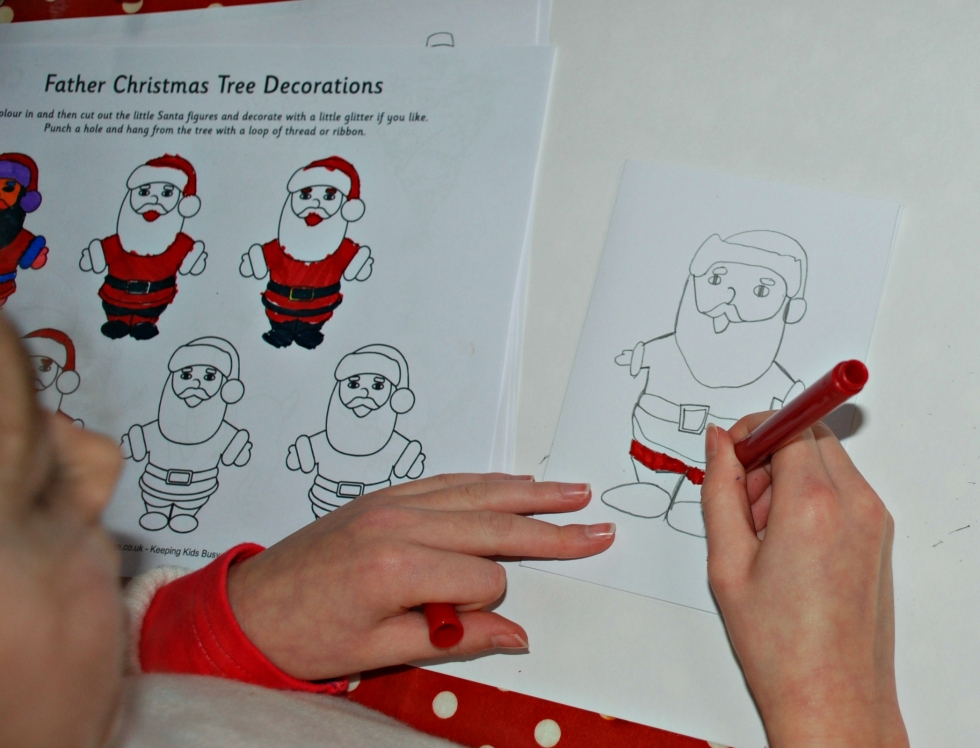 Creating her own Christmas cards by copying the Father Christmas tree decorations page