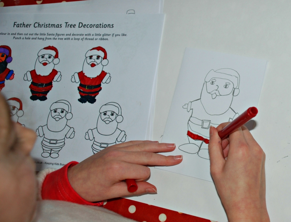 Creating her own Christmas cards by copying the Father Christmas tree decorations page