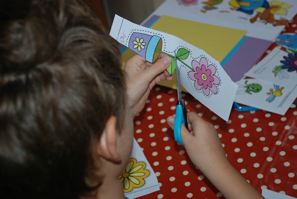 Cutting out images for his bookmarks