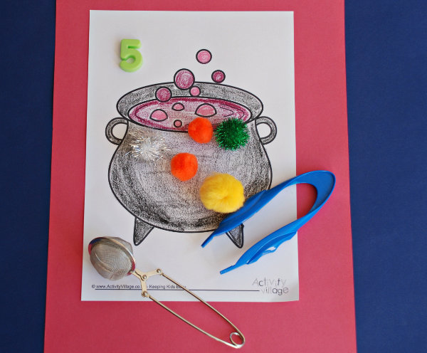 Using the cauldron colouring page with a pair of tweezers and magnetic letters
