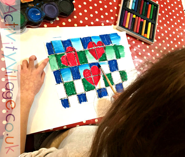 Adding watercolours to her oil pastel resist design