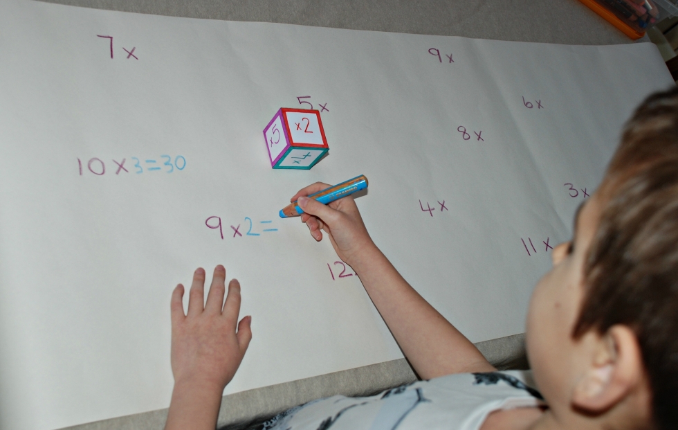 Using his times tables dice cube to practise times tables