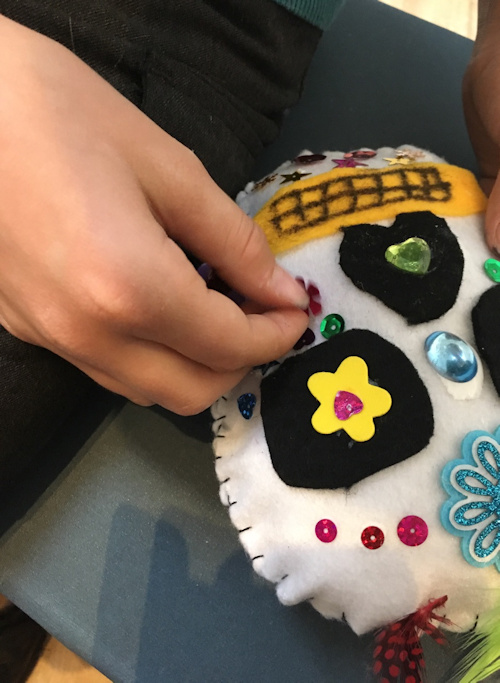 Decorating his sugar skull