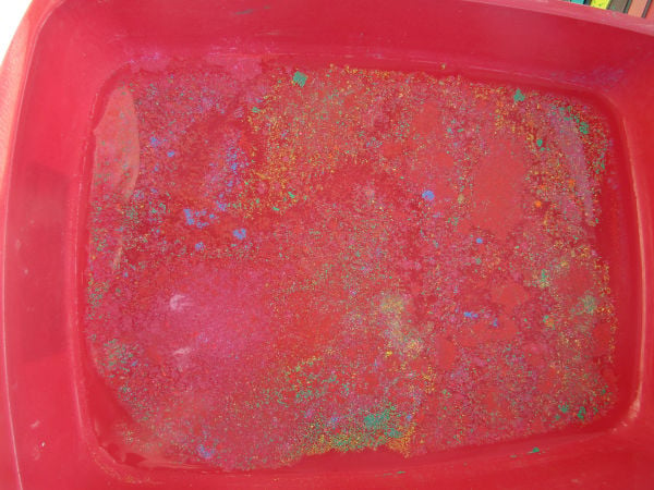 Pastel "dust" floating on top of water in tray