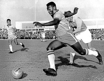 Pele dribbling past a defender 