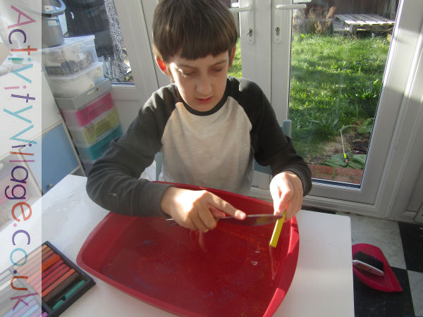 Sam scraping pastels over the water tray