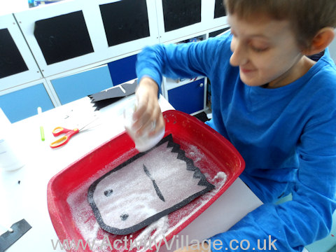 Sam sprinkling glitter onto his stained glass ghost